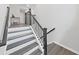 Modern staircase with dark wood treads and black railing at 2302 Village Amble Loop, Lutz, FL 33558