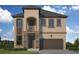 Elegant two-story home featuring a stone facade, covered balcony, and two-car garage at 3022 W Cass St, Tampa, FL 33609