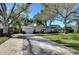 One-story home with a brick facade, a well-maintained lawn, and mature trees and landscaping at 3621 S Belcher Dr, Tampa, FL 33629