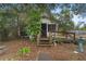 Charming cottage-style home with a screen porch and rustic wooden steps, nestled among lush trees at 3623 Whittier St, Tampa, FL 33619