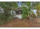 Charming cottage-style home with a screen porch and rustic wooden steps surrounded by greenery at 3623 Whittier St, Tampa, FL 33619