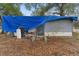 Exterior rear view of a home needing repair covered by a tarp, with visible damage at 3623 Whittier St, Tampa, FL 33619
