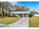 Inviting single-story home showcasing manicured landscaping, a covered carport, and a tidy front lawn at 36343 Ionno Ct, Zephyrhills, FL 33541