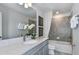 Well-lit bathroom with a vanity, large mirror, a tub with shower, and neutral decor at 36424 Sespe Creek Ct, Zephyrhills, FL 33540