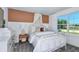Inviting bedroom with a queen bed, dresser, night stand, and a large window at 36424 Sespe Creek Ct, Zephyrhills, FL 33540