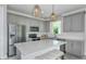 Modern kitchen featuring stainless steel appliances, grey cabinets, and a large center island at 36424 Sespe Creek Ct, Zephyrhills, FL 33540