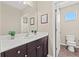 Bright bathroom with double sink vanity, brown cabinets, and a door that leads to the toilet at 4509 Golden Gate Cv, Bradenton, FL 34211