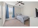 Cozy bedroom featuring a ceiling fan and a full sized bed with blue accents, and large window at 4509 Golden Gate Cv, Bradenton, FL 34211