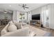 Comfortable living room with hardwood floors, large windows, and a television at 4509 Golden Gate Cv, Bradenton, FL 34211