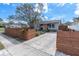 Charming single-story home with modern gray brick driveway, natural landscaping, and a warm, inviting pink front door at 500 49Th N Ave, St Petersburg, FL 33703