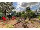 Lush backyard featuring a seating area, mature trees, and galvanized steel planters at 520 48Th N Ave, St Petersburg, FL 33703