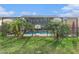 A beautiful backyard with a screened-in pool area, tropical plants, and a privacy fence at 5914 Falconwood Pl, Lithia, FL 33547