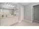 Bright bathroom with a dual sink vanity, a large mirror, and a shower with glass doors at 5914 Falconwood Pl, Lithia, FL 33547
