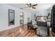 Inviting bedroom with wood floors, a gray sofa, and ensuite bathroom at 5914 Falconwood Pl, Lithia, FL 33547