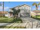 A two-story home with a well-manicured lawn, a large driveway, and well-placed tropical foliage at 5914 Falconwood Pl, Lithia, FL 33547