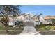 Two story home with a gray exterior, lush lawn, and a palm tree in the front yard at 5914 Falconwood Pl, Lithia, FL 33547