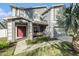 Close up on the house featuring manicured landscaping, a covered seating area, and red front door at 5914 Falconwood Pl, Lithia, FL 33547