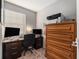 Inviting home office featuring a desk, dual monitors, wooden storage cabinet and natural light from the window at 5914 Falconwood Pl, Lithia, FL 33547