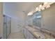 Bathroom with double sinks, granite countertops, and a glass-enclosed shower at 6004 Sweet Birch Dr, Riverview, FL 33578