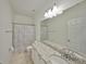 Bathroom features a granite-topped vanity, large mirror, and tiled floor at 6004 Sweet Birch Dr, Riverview, FL 33578