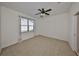 Bright bedroom with a ceiling fan, large window, and neutral carpeting at 6004 Sweet Birch Dr, Riverview, FL 33578