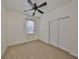 This carpeted bedroom includes a ceiling fan, window and double door closet at 6004 Sweet Birch Dr, Riverview, FL 33578