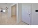 Hallway leads to the living room, features tile floors, white trim and a clear view of the kitchen at 6004 Sweet Birch Dr, Riverview, FL 33578
