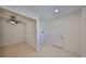Hallway featuring tile floors, white walls, and a ceiling fan leading to other rooms at 6004 Sweet Birch Dr, Riverview, FL 33578
