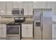 Stainless steel oven and refrigerator, granite countertops, and tiled backsplash at 6004 Sweet Birch Dr, Riverview, FL 33578