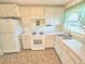 Cozy kitchen with white cabinetry, a gas range, and ample counter space at 6075 Shore S Blvd # 605, Gulfport, FL 33707