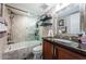 Elegant bathroom featuring a shower-over-tub with glass doors, vanity, and decorative shelving at 6211 Sun Blvd # 115, St Petersburg, FL 33715