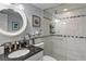 Updated bathroom with black countertop, round mirror, and glass-enclosed tiled shower at 6268 Palma Del Mar S Blvd # 101, St Petersburg, FL 33715