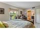 Bedroom featuring a desk area, a view of outside greenery, and an ensuite bathroom at 6268 Palma Del Mar S Blvd # 101, St Petersburg, FL 33715