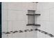 Close up of tiled shower with built-in shelves and black and white accent tiles at 6268 Palma Del Mar S Blvd # 101, St Petersburg, FL 33715