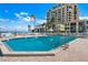 Large swimming pool deck with lounge chairs, palm trees, and nearby condominium at 6268 Palma Del Mar S Blvd # 101, St Petersburg, FL 33715