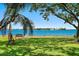 Stunning waterfront view with a bench, framed by lush greenery and a picturesque horizon at 6268 Palma Del Mar S Blvd # 101, St Petersburg, FL 33715