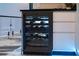 Contemporary bar area with sleek wine fridge and black countertops at 6536 Simone Shores Cir, Apollo Beach, FL 33572