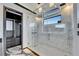 Luxurious glass shower featuring marble walls, river stone floor, rain head, and outside window at 6536 Simone Shores Cir, Apollo Beach, FL 33572