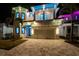 Nighttime view of a luxurious home with modern lighting and a spacious two-car garage at 6536 Simone Shores Cir, Apollo Beach, FL 33572