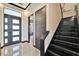 Stunning foyer with sleek black staircase, modern doors, and glossy tile flooring exudes sophistication at 6536 Simone Shores Cir, Apollo Beach, FL 33572