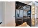 Close-up of black fridge and oven combo, with sleek, glossy black cabinetry at 6536 Simone Shores Cir, Apollo Beach, FL 33572