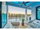 Covered patio with comfortable lounge chairs, outdoor ceiling fan, and a serene pool view at 6536 Simone Shores Cir, Apollo Beach, FL 33572