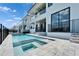 Backyard view featuring pool and spa of modern home with balconies and patio at 6536 Simone Shores Cir, Apollo Beach, FL 33572