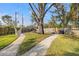 Expansive backyard featuring a hammock, mature trees, and stone pathways, creating a serene outdoor space at 10098 Oaks Ln, Seminole, FL 33772