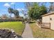 Landscaped backyard with paved walkway, fire pit and deck at 10098 Oaks Ln, Seminole, FL 33772