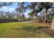 Spacious backyard featuring a basketball court, a swing, and mature trees, perfect for outdoor activities at 10098 Oaks Ln, Seminole, FL 33772