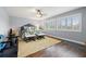 Bright bedroom with hardwood floors, ceiling fan, bench seating, and natural light from windows at 10098 Oaks Ln, Seminole, FL 33772