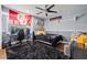 Bedroom with dark carpet, desk, shelves, ceiling fan, and flag displayed on the wall at 10098 Oaks Ln, Seminole, FL 33772