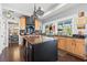 Spacious kitchen featuring an island, light wood cabinets, and dark countertops at 10098 Oaks Ln, Seminole, FL 33772