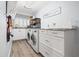 Bright laundry room with modern washer and dryer, white cabinets and granite countertops at 10098 Oaks Ln, Seminole, FL 33772